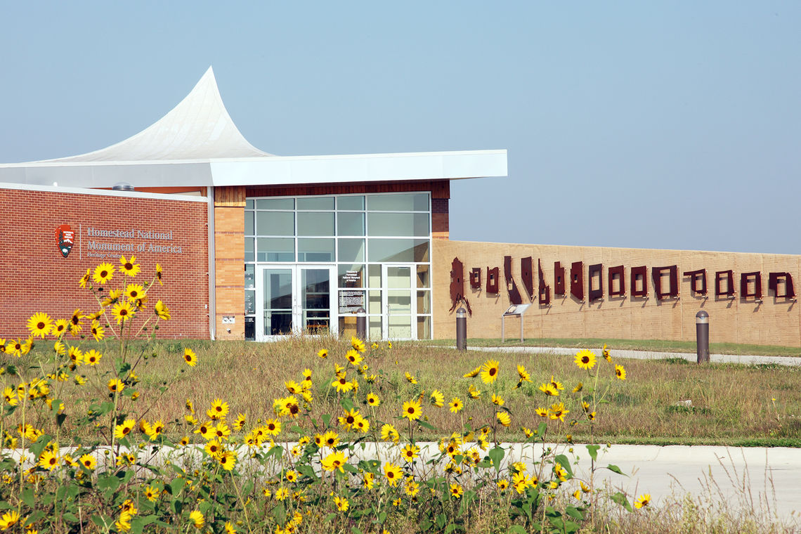 Visitors to the Homestead Heritage Center park their car in the one-acre square parking lot (1/160th of a homestead) and approach on foot. Silhouettes of each homesteading state adorn the site wall slowly introducing visitors to the subject matter as they approach the museum.