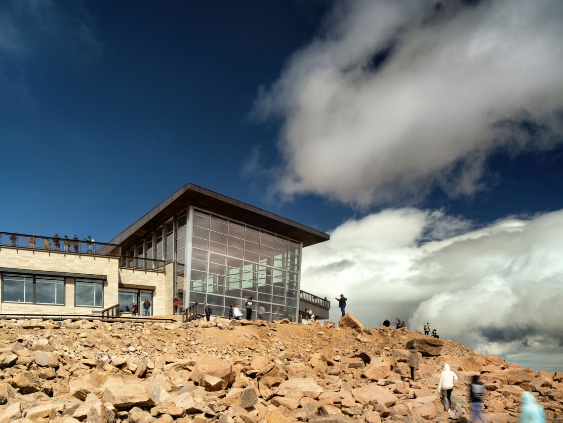 Captivating but also functional, the building is sited to take advantage of the unique environmental conditions. Nestled into the mountain, exposure to the harsh winds is minimized, while the mass of the building provides sheltered outdoor areas to enjoy the views. The building’s southern orientation maximizes daylighting and reduces energy needs. A highly insulated concrete shell and in-floor radiant heating, together with the thermal mass of the stone cladding, help to retain heat. These strategies equip the building for an extreme climate, where winter temperatures can reach as low as negative 40 degrees.